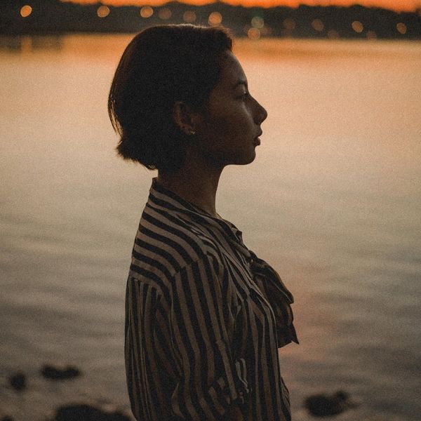 Person in a calm, balanced pose against a serene backdrop.